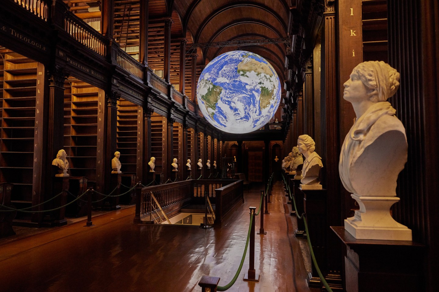Image of Gaia in the Long Room, with white sculptures along the aisles of bookshelves