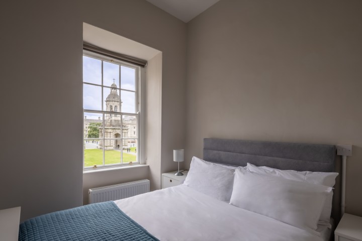 A bedroom featuring a window with a view of Trinity Front Square in the accommodation at Trinity College Dublin.