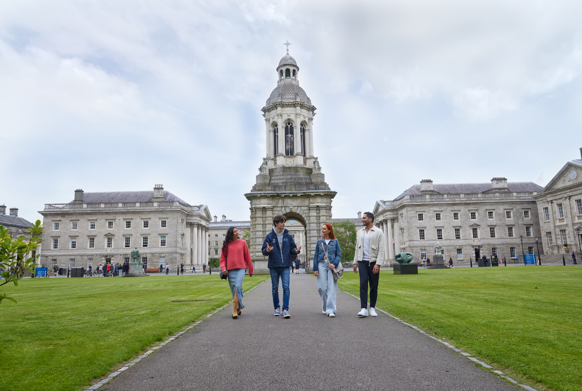 A Trinity guide with three tourists walking through Front Square during the historical walking tour of Trinity College.