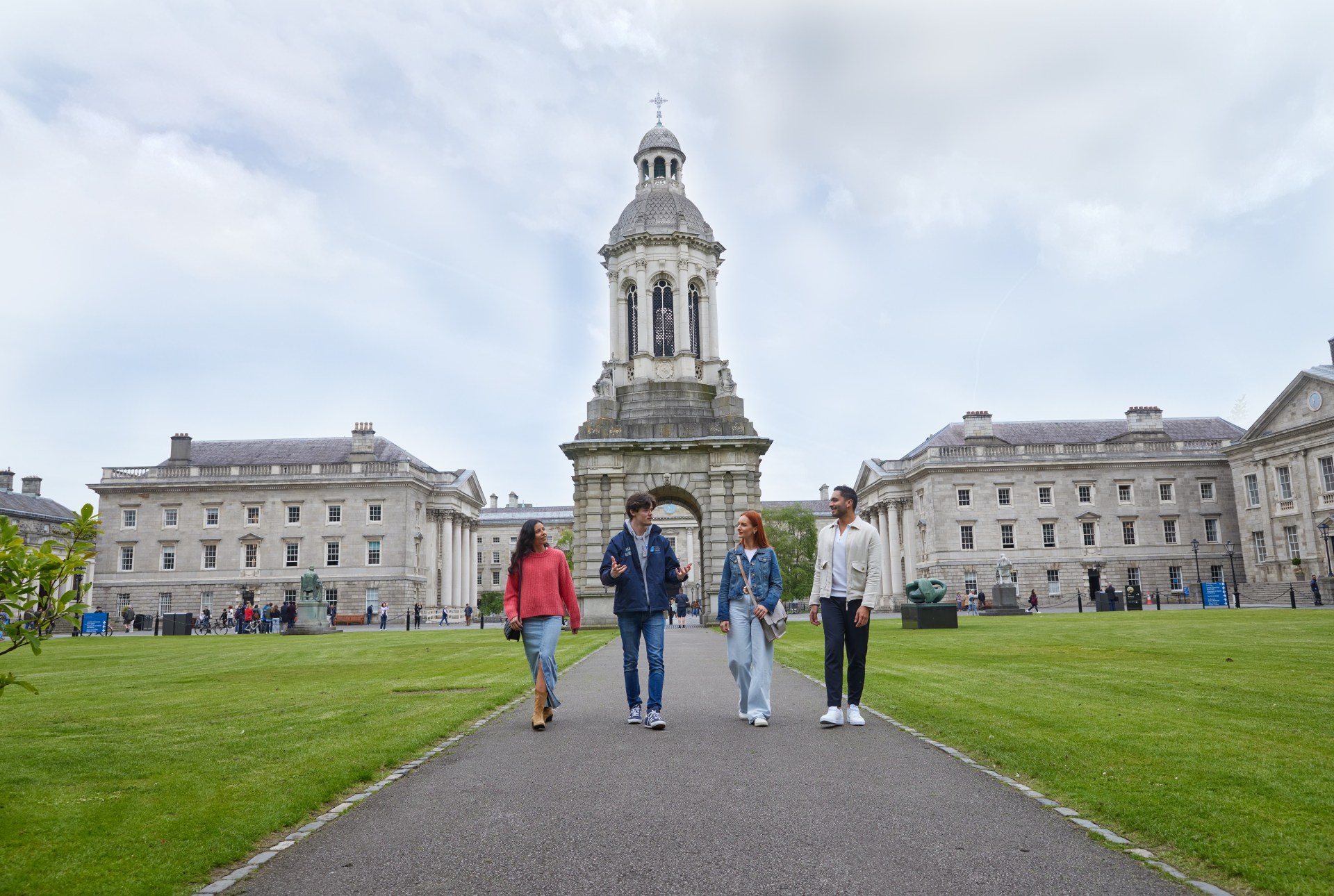 A Trinity guide with three tourists walking through Front Square during the historical walking tour of Trinity College.